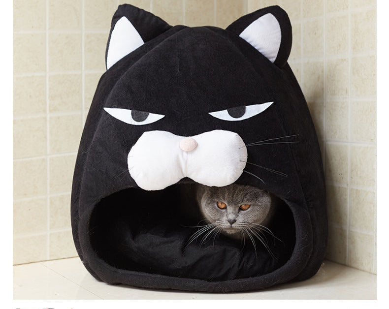 Black cat-shaped pet bed with a cat peeking out from inside, against a tiled wall background.