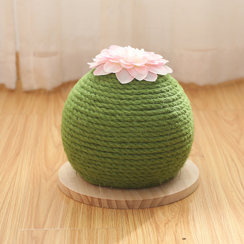 Green scratching ball with a white flower on a wooden surface