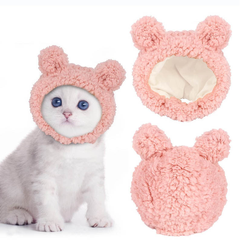 Cat wearing a pink fluffy bunny costume with two additional bunny ears on a white background