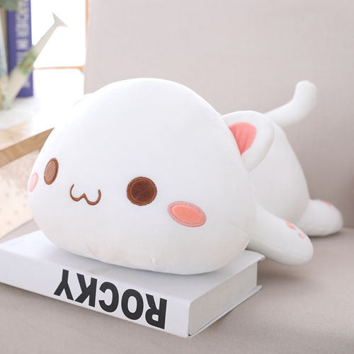 Cute plush cat toy on a book with a neutral background