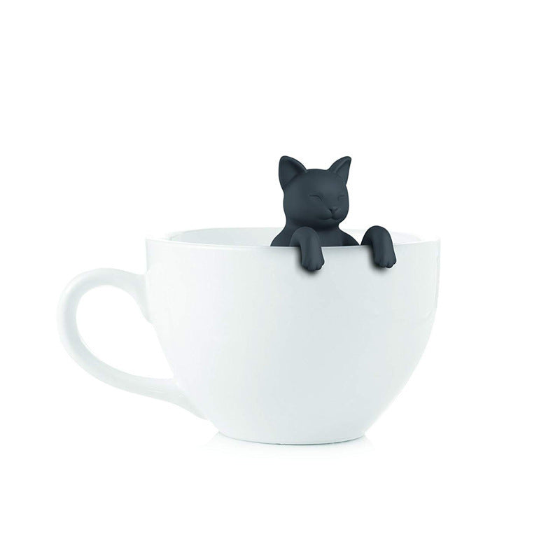 White ceramic cup with a black cat figurine on a white background