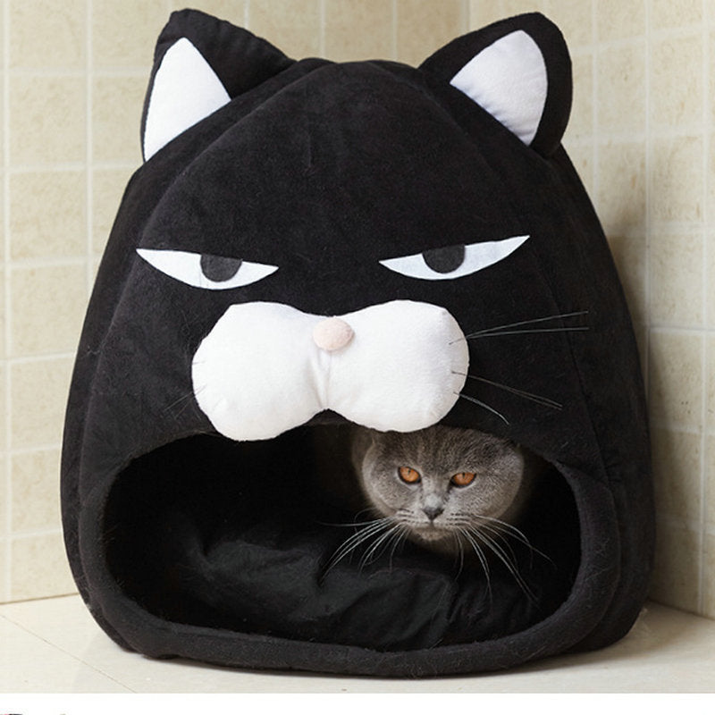 Black cat-shaped pet bed with a gray cat inside, against a beige tiled wall.