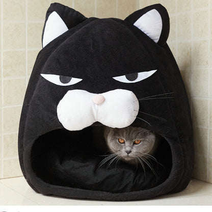 Black cat-shaped pet bed with a gray cat inside, against a beige tiled wall.