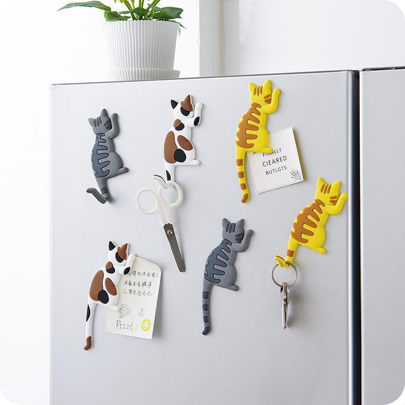 Cat-shaped magnetic items on a refrigerator door
