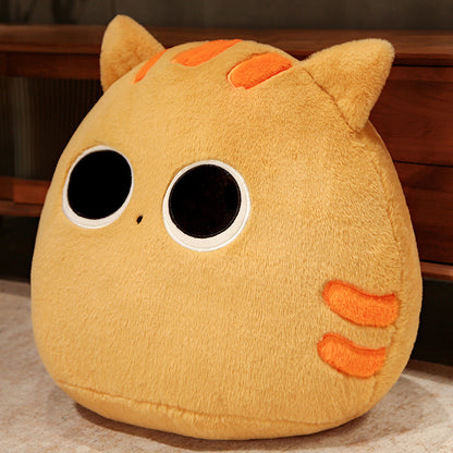 Plush toy resembling a cat with orange accents on a wooden surface