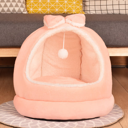 Pink cat bed with a bow on a wooden floor in front of a sofa - Neferpaws