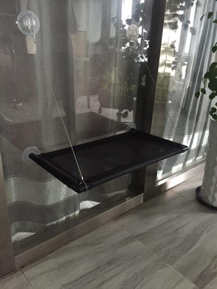 Black pet gate with suction cups on a glass door