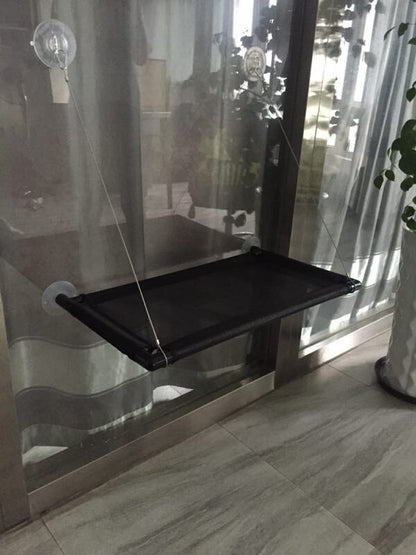 Black pet gate with suction cups on a glass door