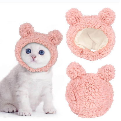 Cat wearing a pink fluffy bunny costume with two additional bunny ears on a white background