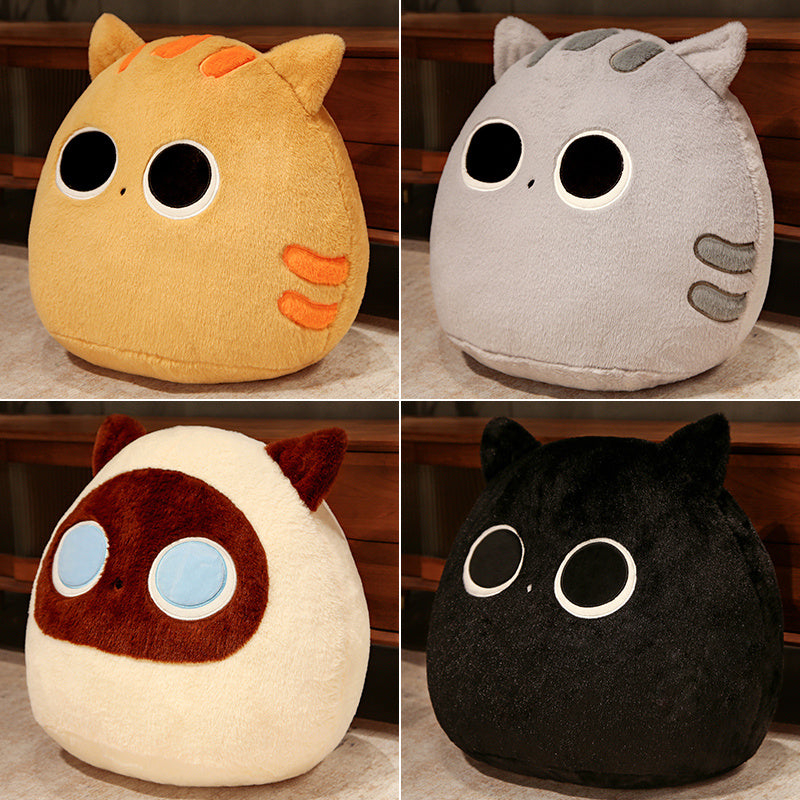 Four plush toys in different colors with large eyes on a wooden surface.