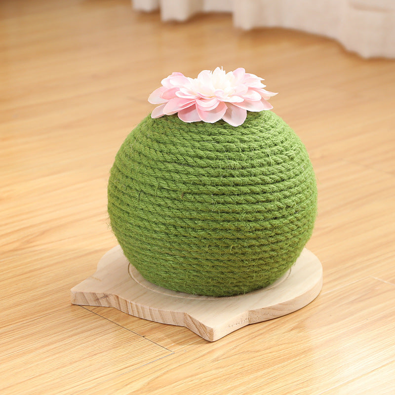 Green scratching ball with a white flower on a wooden surface