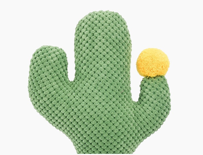 Green knitted cactus-shaped toy with a yellow ball on a white background