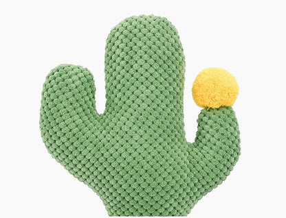 Green knitted cactus-shaped toy with a yellow ball on a white background