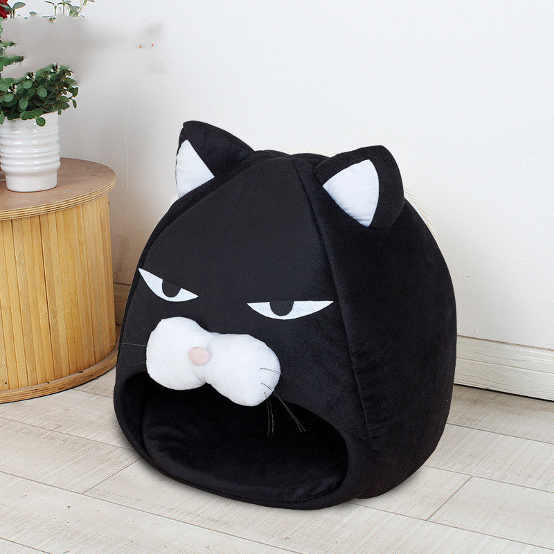 Black cat-shaped pet bed on a light wooden floor with a plant in the background
